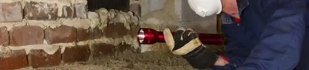Pest control technician inspecting a crawl space for ant activity and entry points in Houston, TX