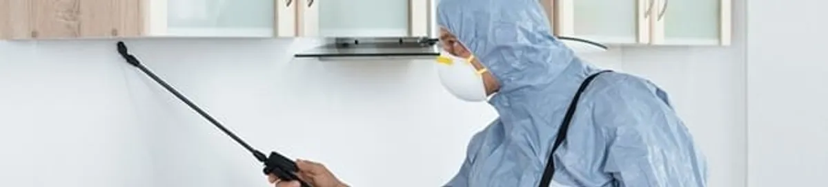 Termite treatment technician applying indoor pest control spray in Houston, TX